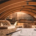 Charpente bois cintré en bois lamellé-collé, intérieur en construction, lumière rasante